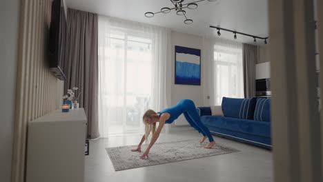 Home-yoga-workout-on-the-carpet-in-the-afternoon-near-the-sofa-and-TV-in-the-living-room.-Morning-exercises-and-yoga-class.-Complex-yoga-exercises-for-balance-and-endurance