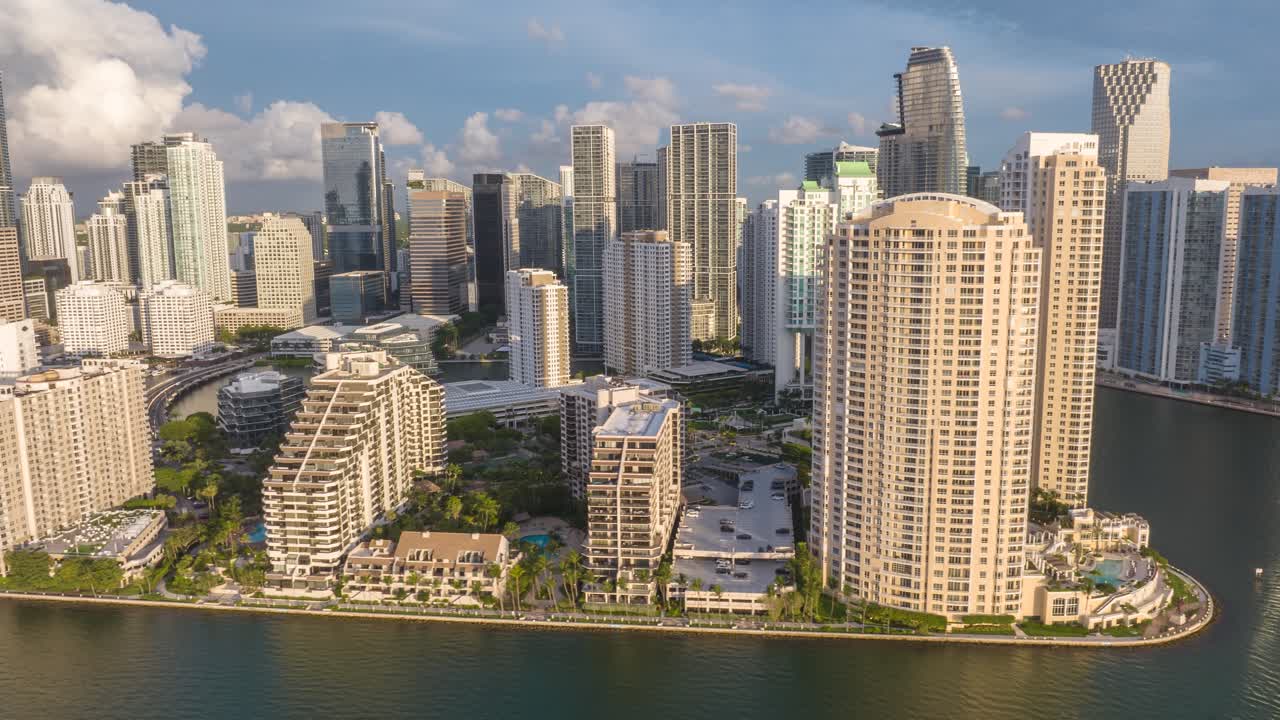 Brickell Key in Miami, Florida. Aerial orbit hyper lapse during golden hour morning sunrise light. Time lapse from drone. Modern skyline.
