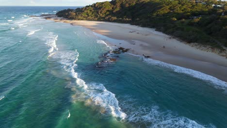 Los-Turistas-Visitan-Una-Playa-Aislada-Con-Arena-Blanca-Al-Atardecer---Mar-De-Coral-En-North-Stradbroke-Island,-Queensland,-Australia