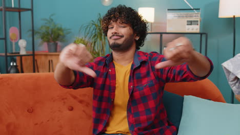 upset indian man showing thumbs down, dislike bad work, disapproval, dissatisfied feedback at home