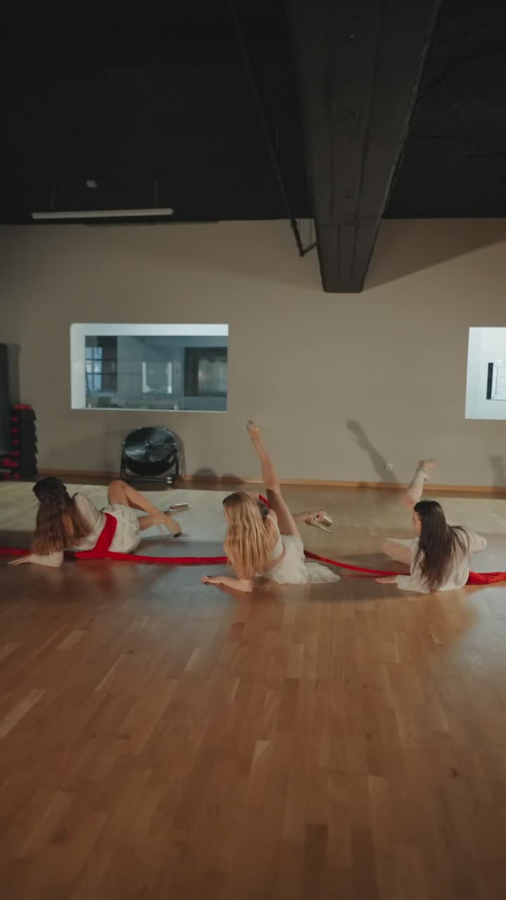 Women practicing contemporary dance with red ribbons