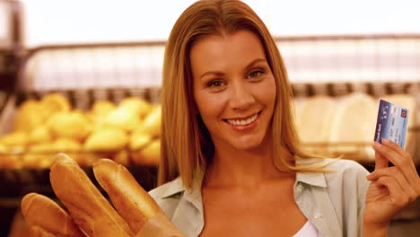 Woman-showing-her-credit-card-in-grocery-store