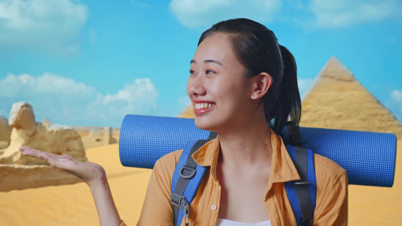 Close Up Of Asian Female Hiker With Mountaineering Backpack Smiling And Pointing To Side While Traveling In Pyramid Of Giza