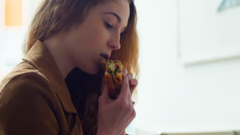 mujer ejecutiva comiendo mientras usa una tableta digital en su escritorio