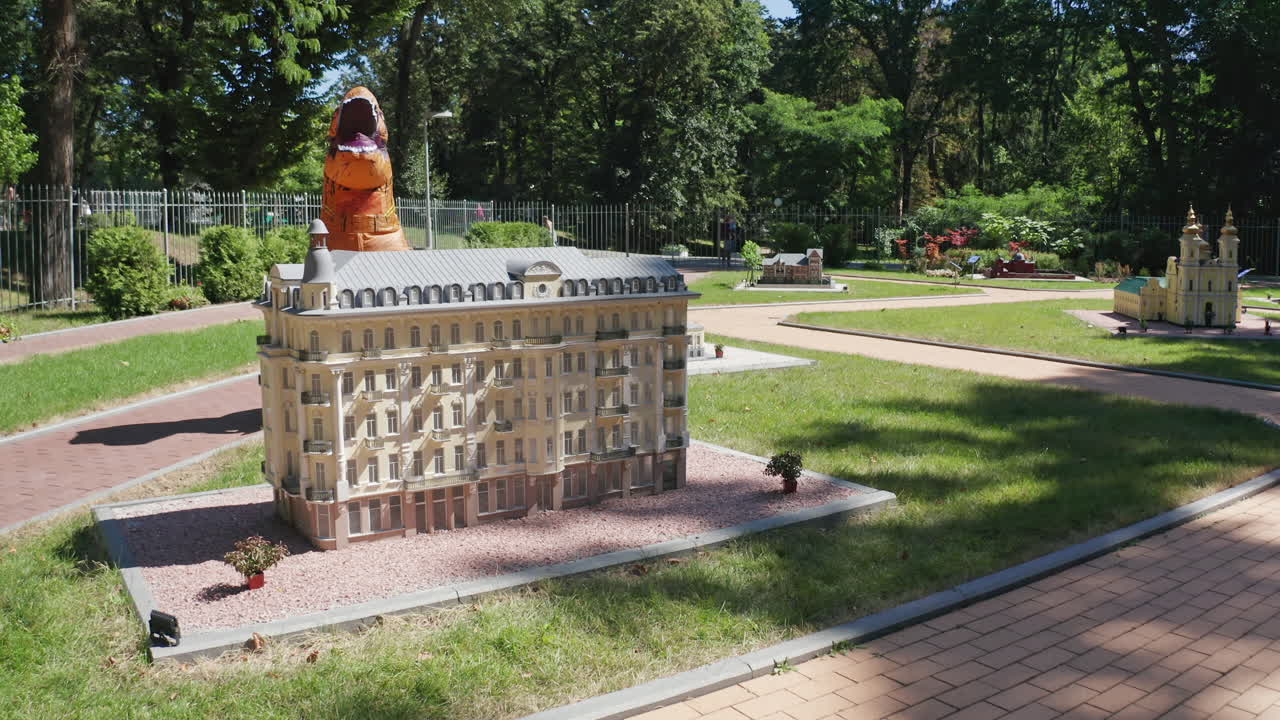 Dinosaur opened his mouth widely standing behind the little building. Tirex dinosaur towering above the house. Top view.