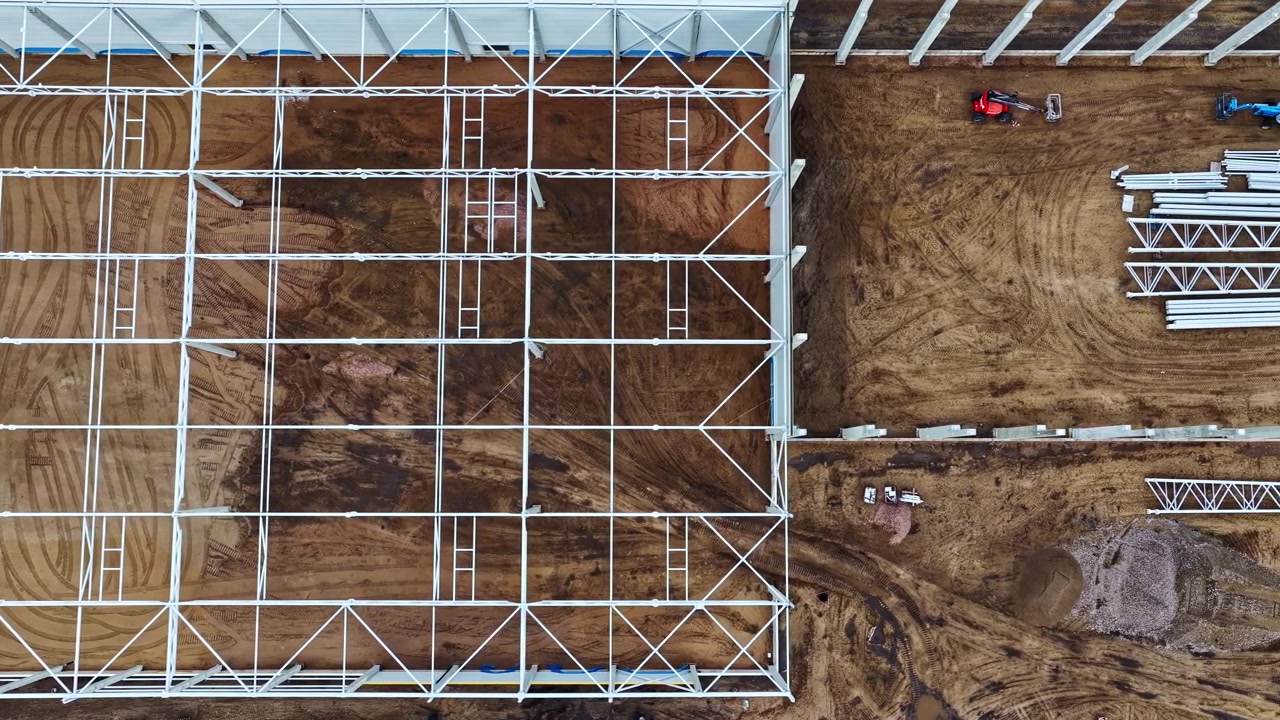 Top-down view showing the construction process of a modern industrial warehouse structure