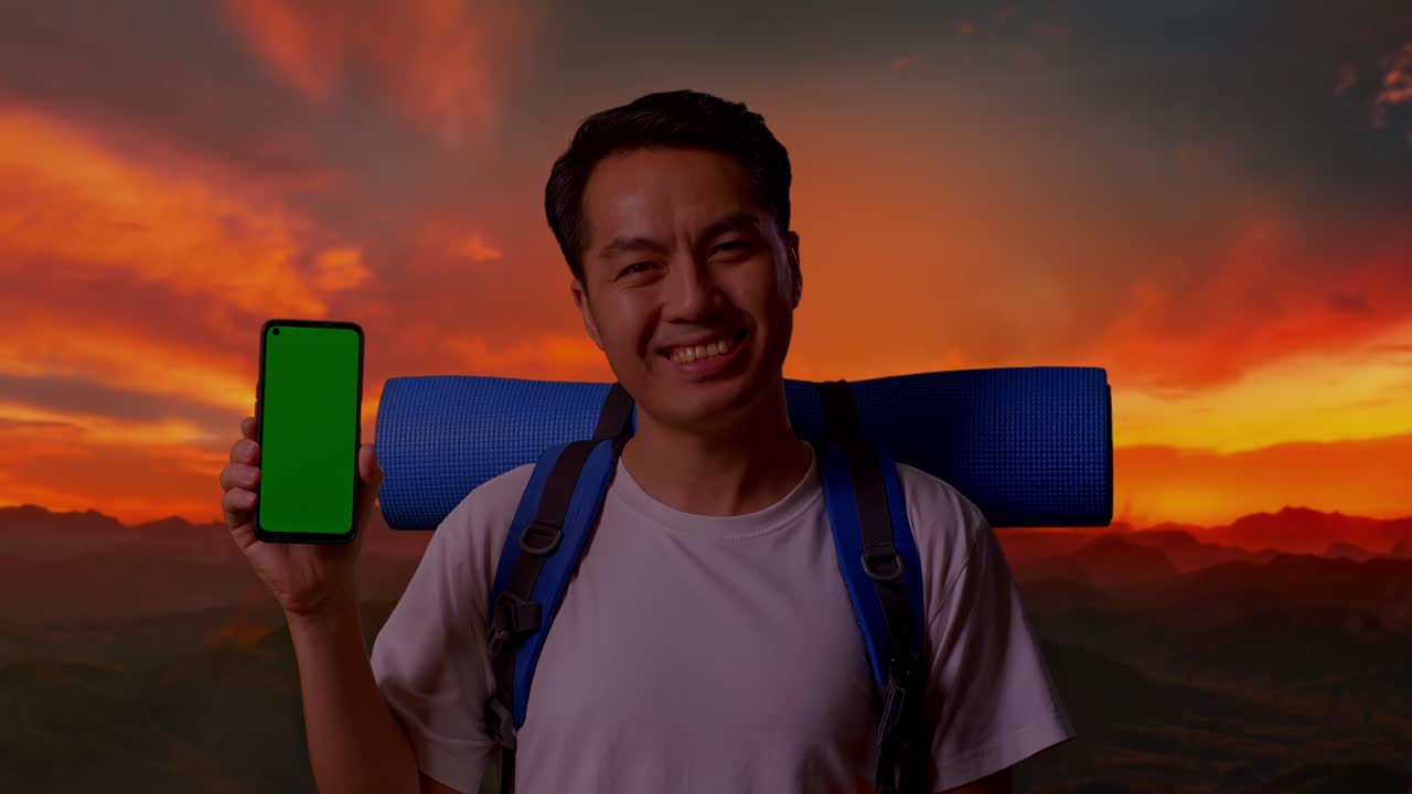 해가 지는 동안 초록색 화면 전화로 웃는 관광객