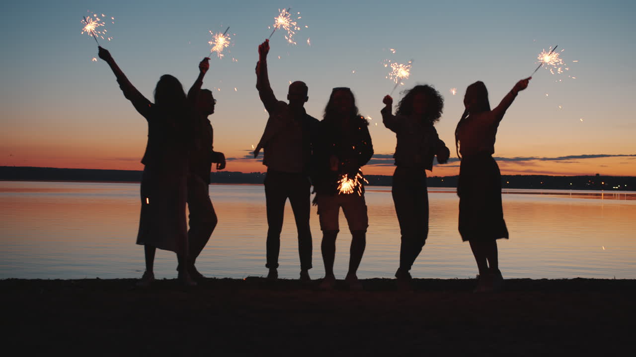 스파클러와 함께 해가 지는 것을 축하하는 친구들
