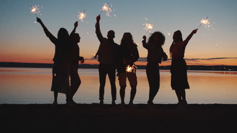 friends celebrating sunset with sparkler