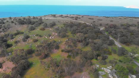 Granite-Island-landscape,-orange-rocks-and-vivid-turquoise-ocean,-aerial-view