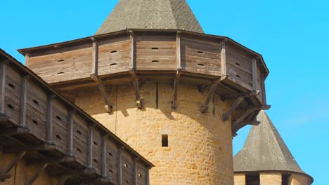 slow descending close-up of a wooden hoarding atop a medieval tower in carcassonne’s historic citadel