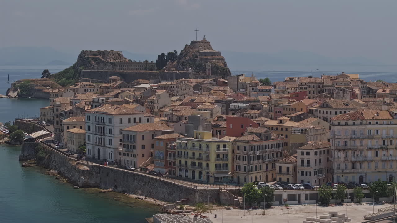 Corfu Greece Aerial v29 flyover port harbor capturing waterfront townscape lined with Venetian-style buildings and old fortress dominating the background - Shot with Mavic 3 Pro Cine - July 17th 2024