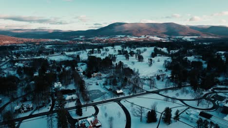 Wide-frame-perspective-of-winter-landscape-among-a-quaint-New-England-town-dressed-in-the-winter-season-with-soft-blue-skies-and-rolling-snow-covered-hills-located-in-Williamstown,-Massachusetts