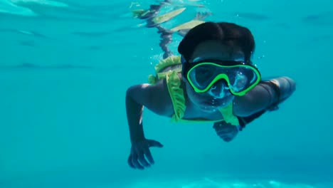 pequeña chica caucásica con máscara y esnórquel nadando, imágenes subacuáticas de gopro