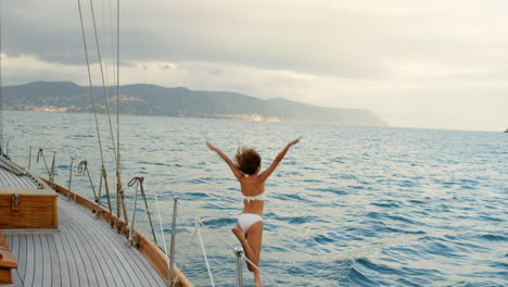 young woman in a white bikini excitedly jumping