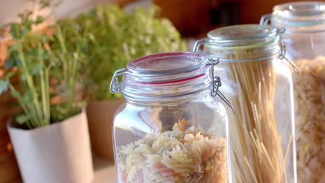 Storage-jars-of-food-on-countertop-in-sunny-kitchen,-slow-motion