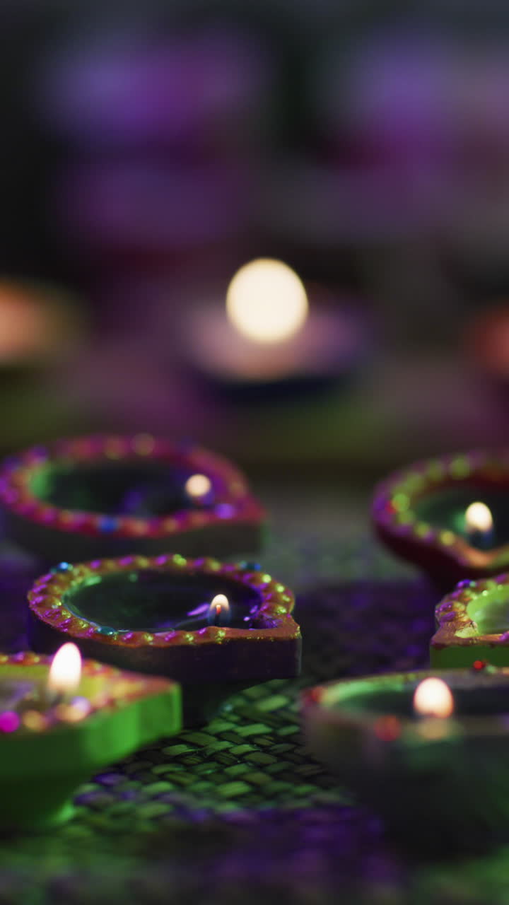 Primo piano verticale di diverse candele Diya verdi.