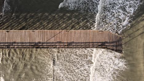 top down drone shot panning left on pawleys island pier destroyed after hurricane ian