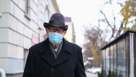 an elderly man with an impressive beard and warm winter clothing stands on a bustling city street filled with energy