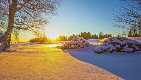 Bright-sun-rises-over-snowy-countryside-landscape,-time-lapse