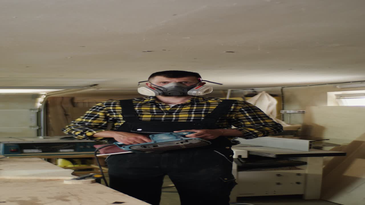 trabajador lijando madera en un taller