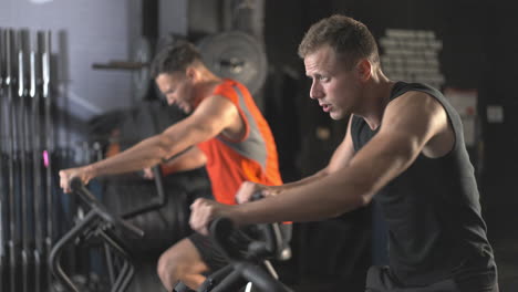 Men exercising on stationary bikes in a gym