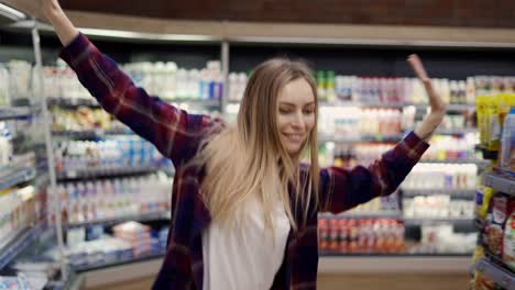 Happy-Young-Woman-Dances-In-Supermarket,-Whirling,-Having-Fun