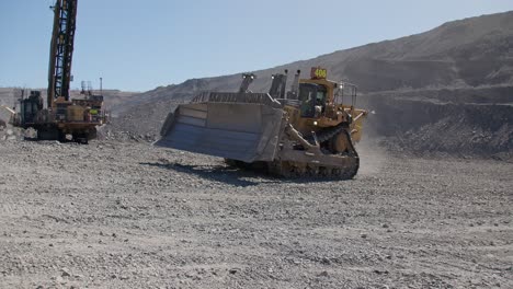 panning shot of an excavator driving at a coal mine