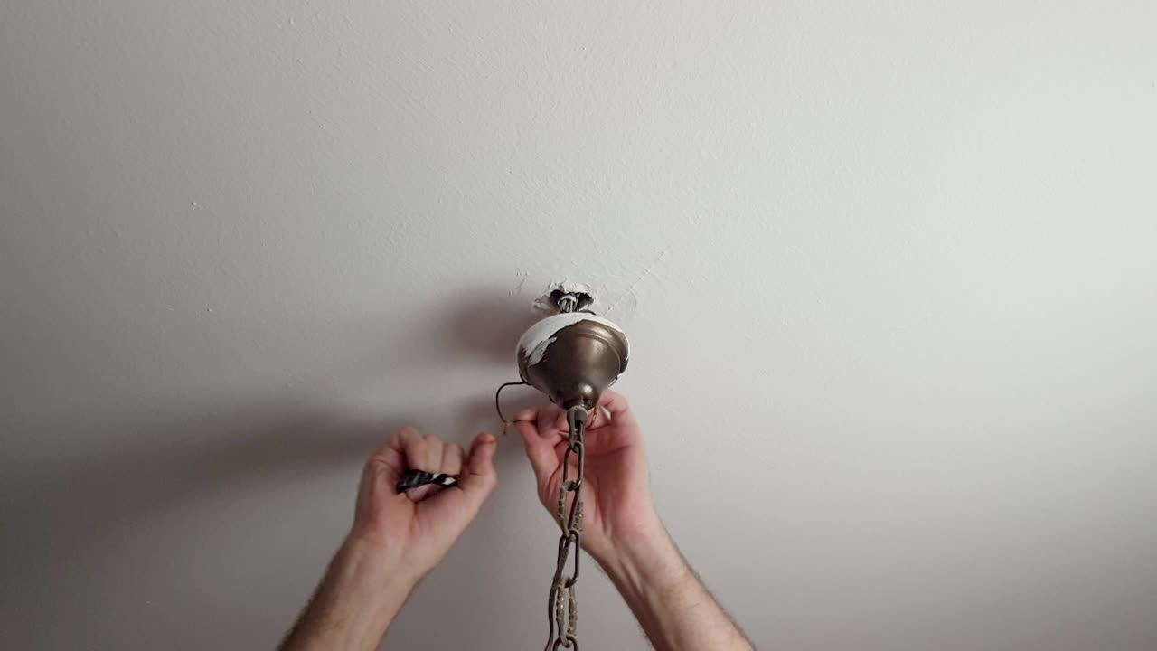 Premium stock video - Disconnecting wires from a chandelier