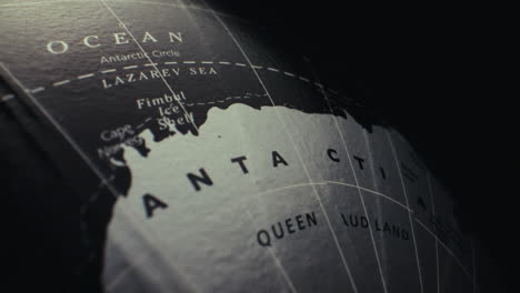 close-up of an antique world globe focusing on antarctica