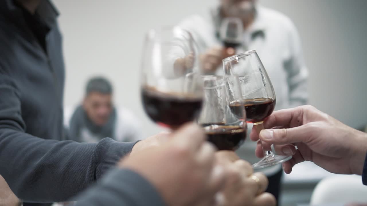 Group of people clinking glasses of red wine while celebrating