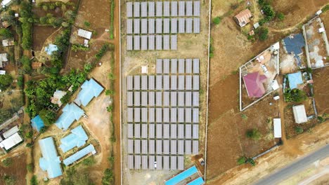 Foque-Hacia-Abajo-De-Una-Granja-De-Paneles-Solares-En-África-Rural--Energía-De-Renovación-Verde-ODS--Granja-Fotovoltaica-De-Células-De-Paneles-Solares