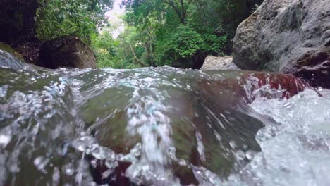 Close-up-slow-motion-of-Rio-Jima-River-flowing-between-rocks-in-idyllic-forest-landscape