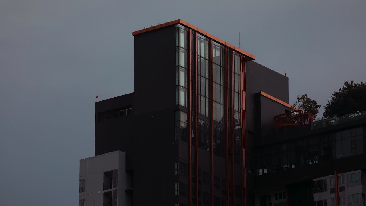 Grattacielo condominiale moderno in primo piano nel centro di Bangkok con timelapse di nuvole che si muovono nel cielo.