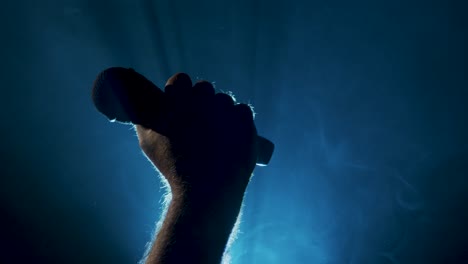 el micrófono se eleva en un tiro sobre un fondo ahumado
