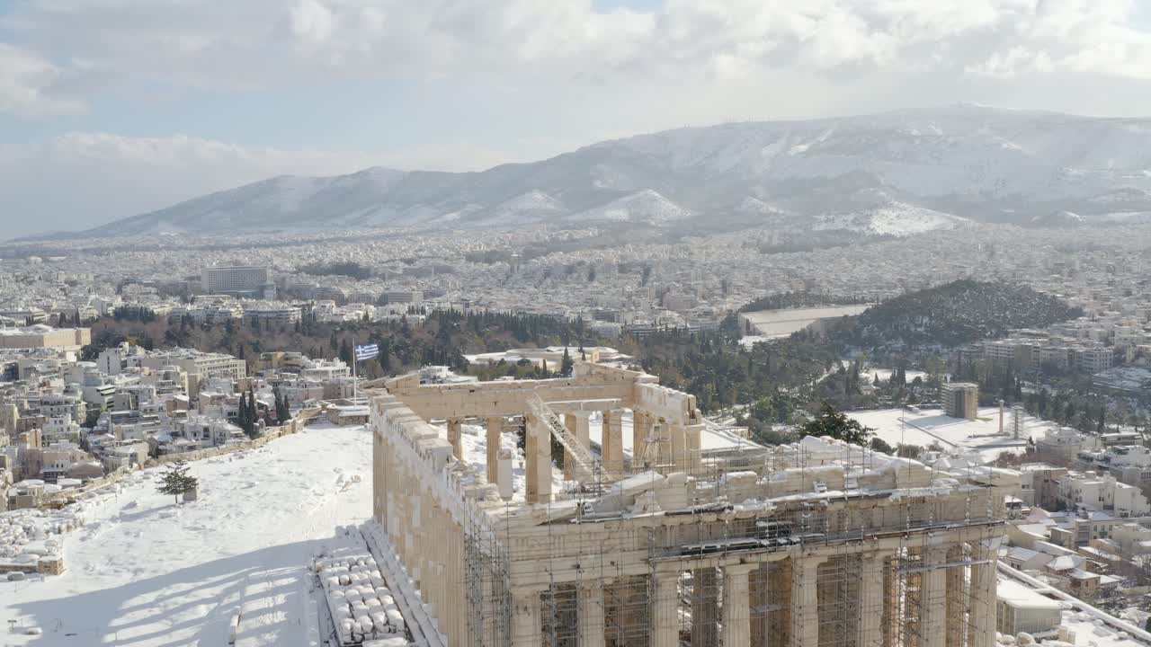vista aérea sobre el templo del partenón cubierto de nieve en la colina de la acrópolis, invierno en atenas - aumento, disparo de drones