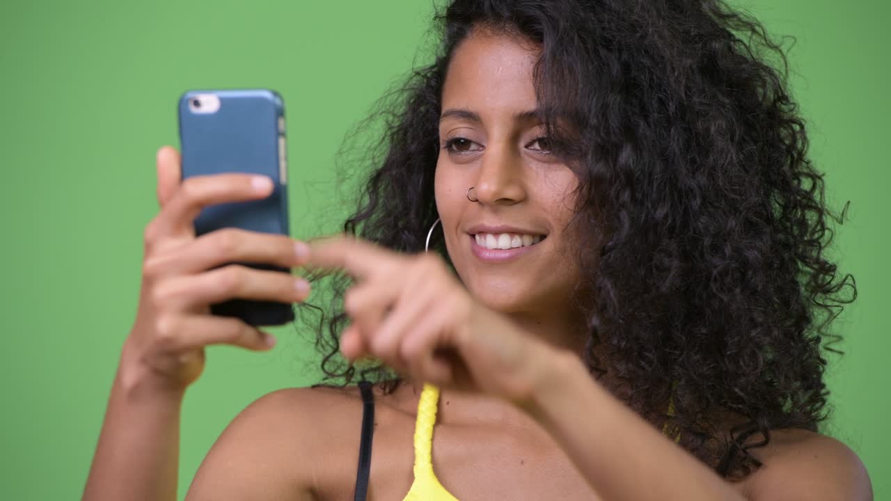 Young beautiful Hispanic woman using phone