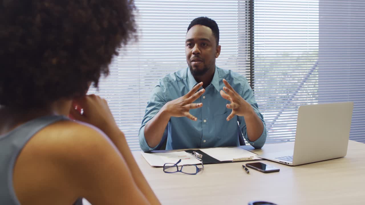 Video of focused diverse businessman and female designer working and talking