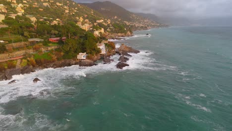 Nervi-En-Génova,-Italia-Con-Olas-Rompiendo-En-La-Costa-Rocosa,-Casas-Ubicadas-En-La-Ladera,-Vista-Aérea