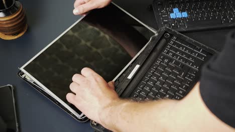 repair of an old laptop, the technician removes the display panel