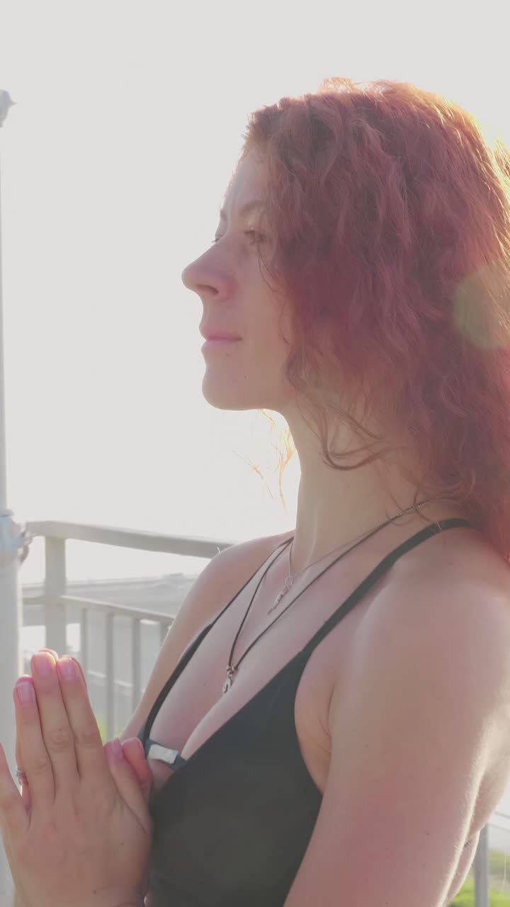 Woman with wavy hair gazing thoughtfully into the distance, illuminated by soft sunlight glow