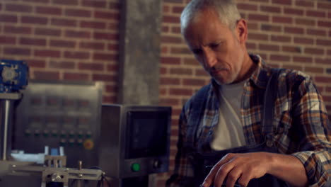 brewery worker checking a machine