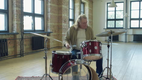 senior drummer playing music in studio