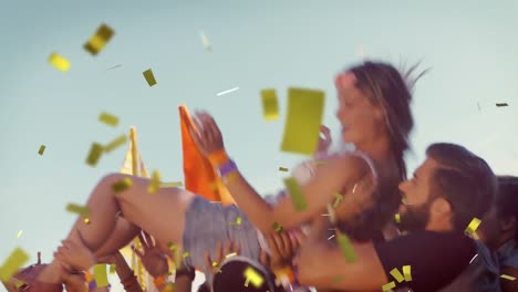 Animation-of-gold-confetti-falling-over-woman-being-thrown-in-the-air-by-happy-friends-outdoors