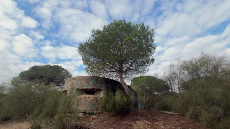 A-concrete-machinegun-bunker,-a-relic-of-wartime-history,-stands-near-the-Spanish-coastline,-embodying-resilience-and-historical-significance-amidst-the-passing-of-time