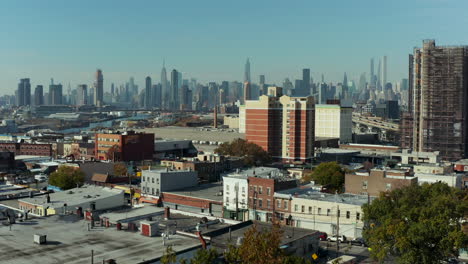 Fly-above-urban-neighbourhood.-Skyline-with-modern-skyscrapers-in-background.-Backwards-reveal-of-historic-Calvary-Cemetery.-New-York-City,-USA