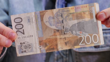 a detailed view of a 200 currency note held confidently, showcasing its intricate design and distinct features