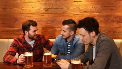 friends interacting while having a glass of beer