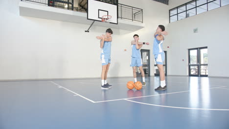 on court, basketball players stretching and preparing for practice with determination