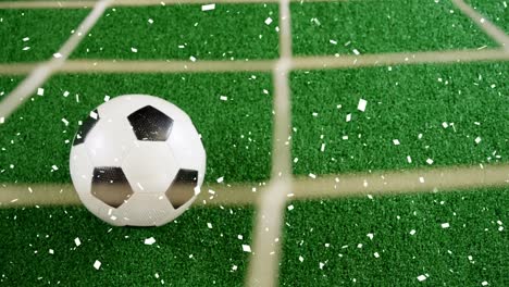 Animation-of-gold-confetti-falling-over-soccer-ball